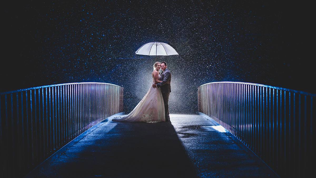 rain umbrella wedding photograph at Lodore Falls Hotel bridge