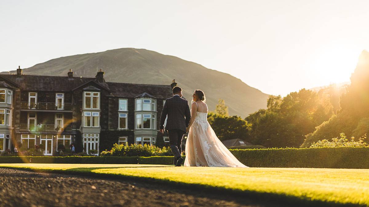 bride and groom walking in the evening sun at inn on the lake