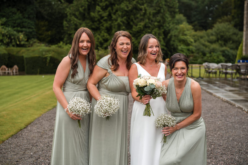 Bride and bridesmaids laughing during portraits at Armathwaite Hall in the Lake District