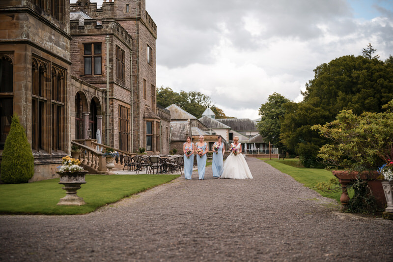 Bride and bridesmaids walking down the driveway at Armathwaite Hall