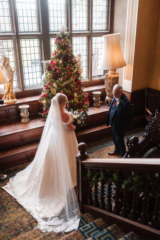 Bride and father on the staircase by the Christmas tree at Armathwaite Hall
