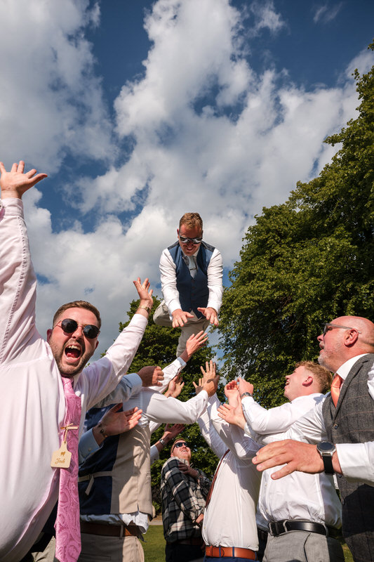 Groom tossed in the air celebration at Armathwaite Hall wedding