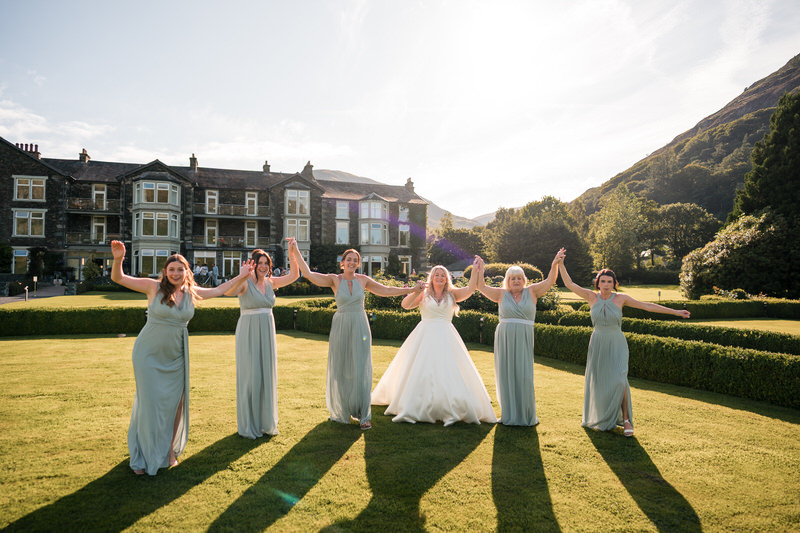 Bride and bridesmaids lineup portrait on the lawn at Inn on the Lake