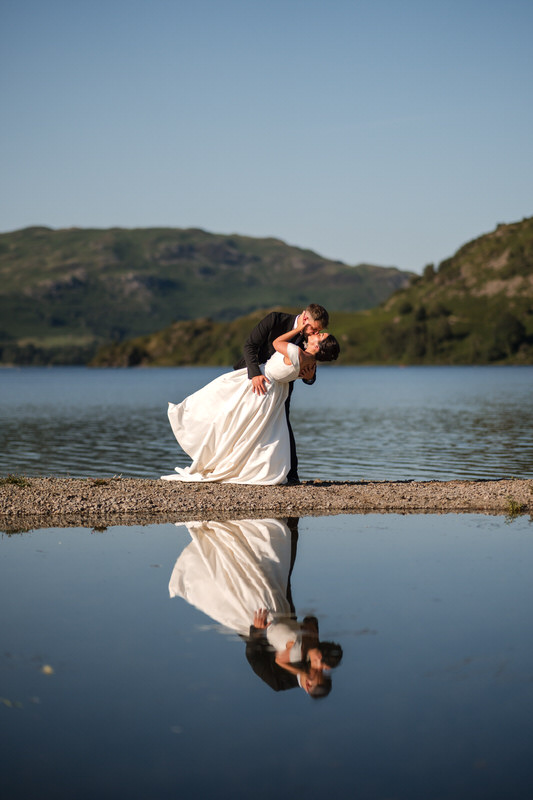 Wedding couple dip kiss with Ullswater reflection at Inn on the Lake