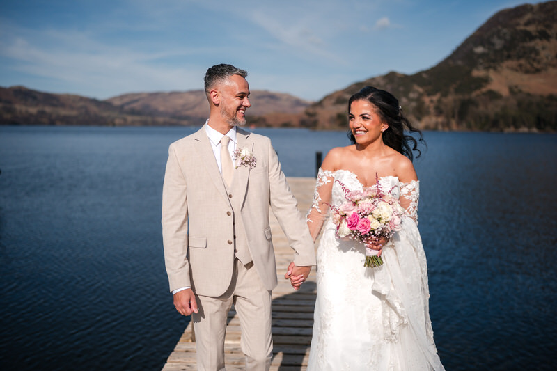 Wedding couple walking portrait on the Ullswater jetty at Inn on the Lake