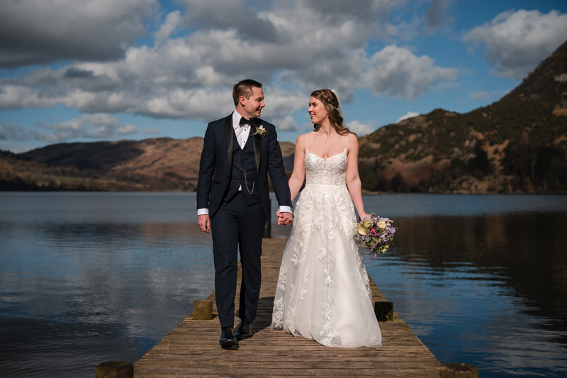 Wedding couple walking along the jetty at Inn on the Lake on Ullswater