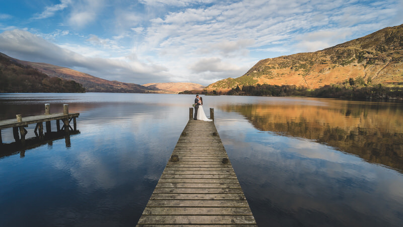 Wedding couple on the Ullswater jetty with reflection at Inn on the Lake