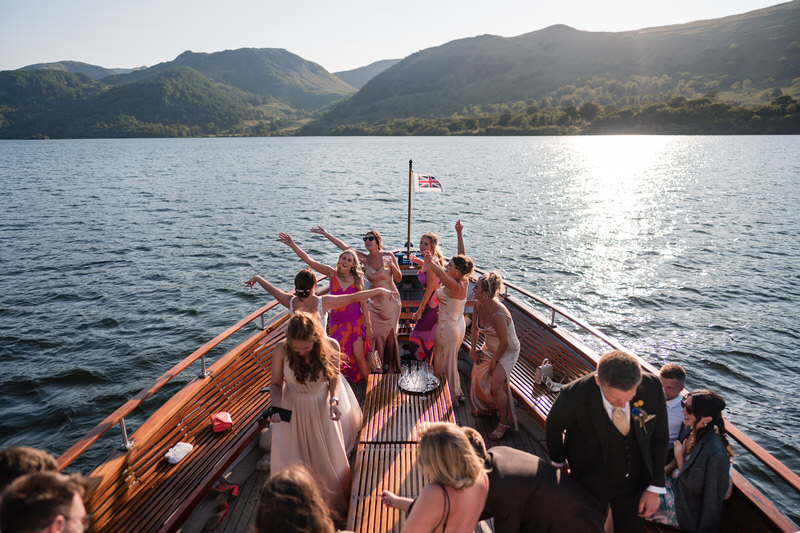 Wedding party celebrating on a boat on Ullswater at Inn on the Lake