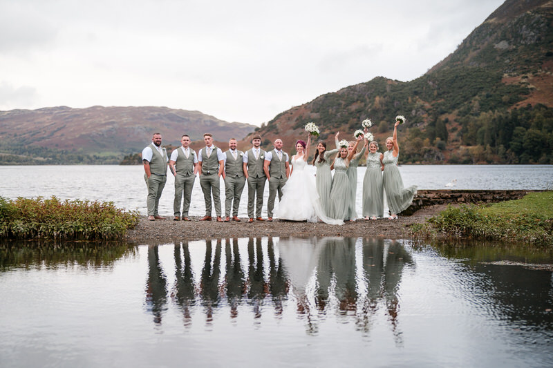 Wedding party portrait by the lakeshore with reflections at Inn on the Lake on Ullswater