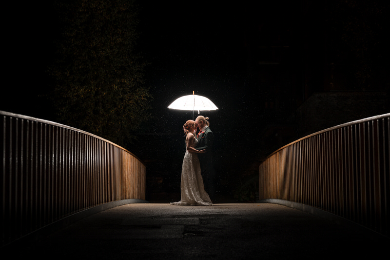 Rainy night wedding portrait on a bridge at Lodore Falls Hotel