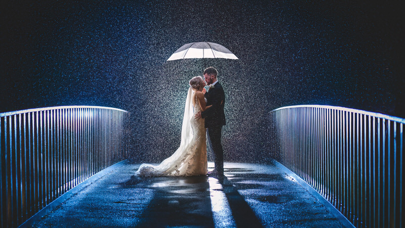 Rainy night bridge wedding portrait at Lodore Falls Hotel