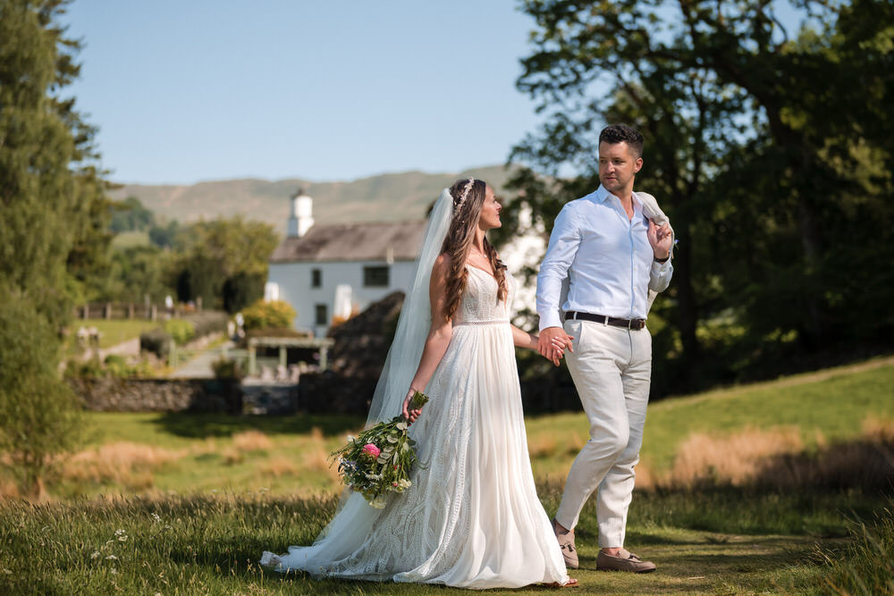 Wedding couple walking away together in the Lake District at Cote How