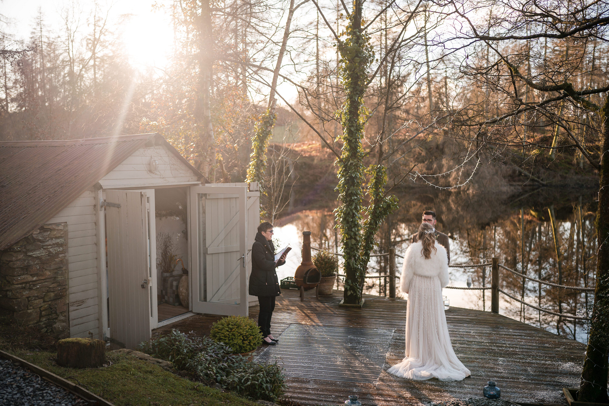 Winter lakeside wedding ceremony at Gilpin Lake House with low sun