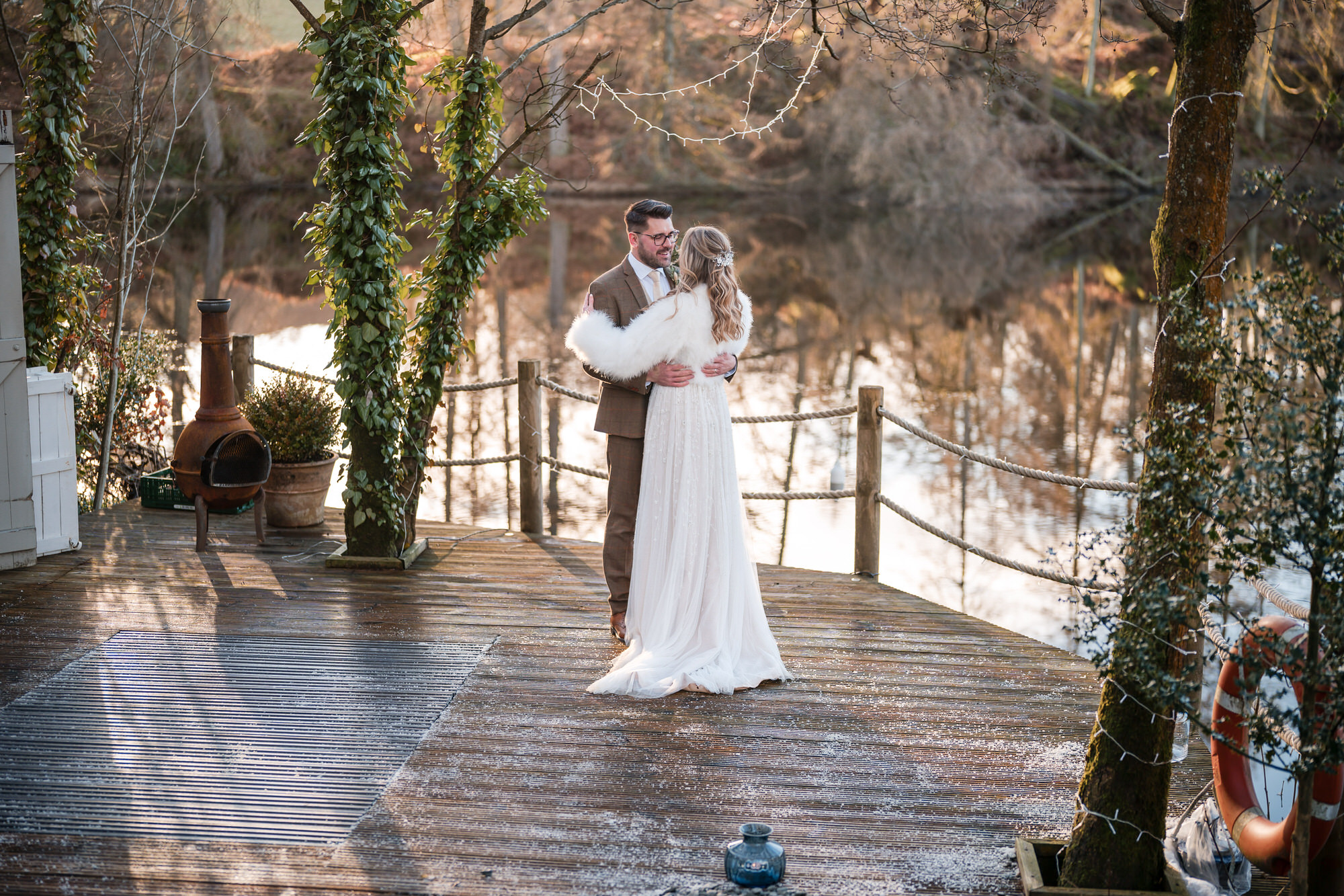 Winter wedding portrait on the deck beside the lake at Gilpin Lake House