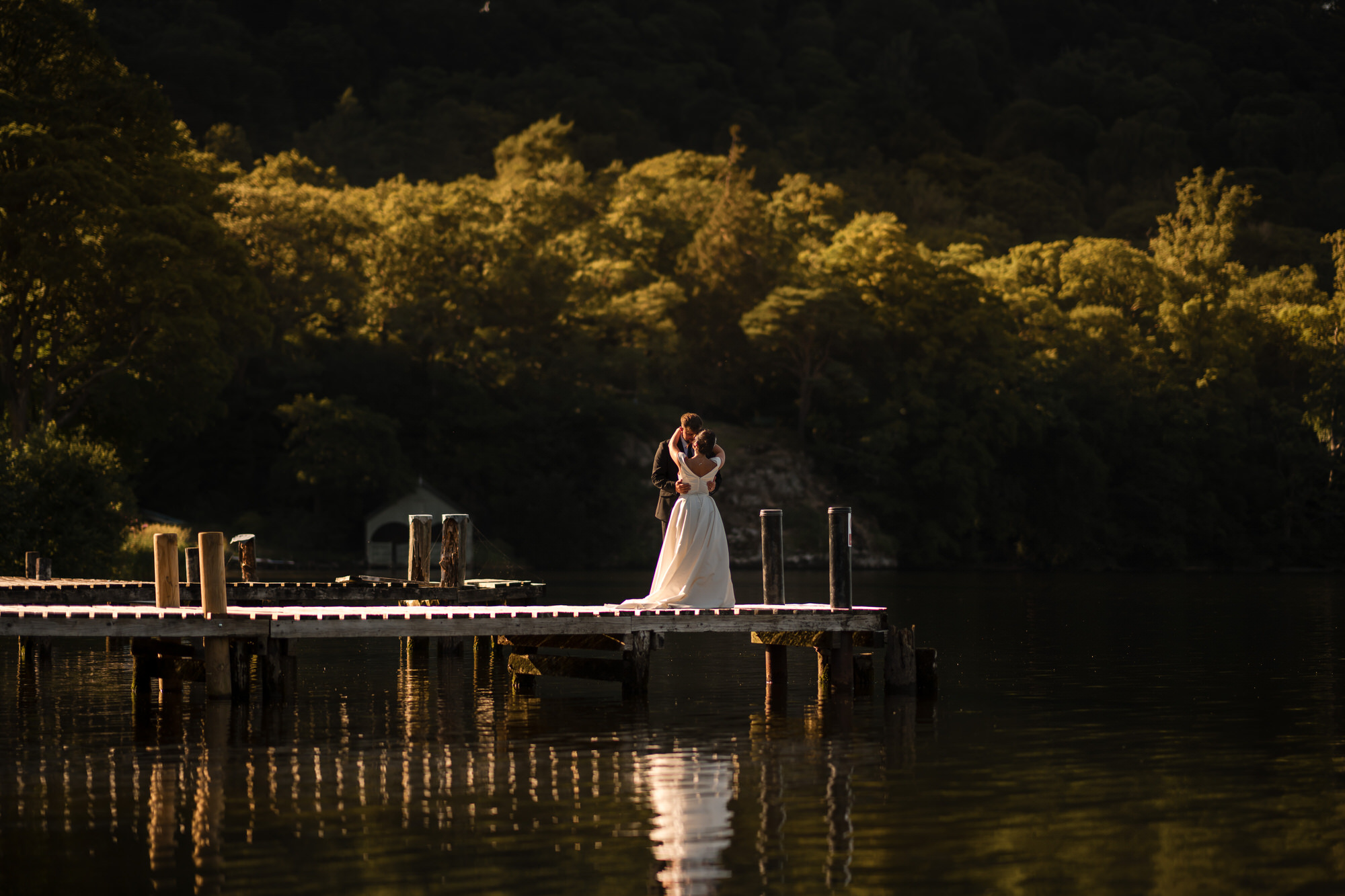 Dan and Amy embracing on the Ullswater jetty in evening light