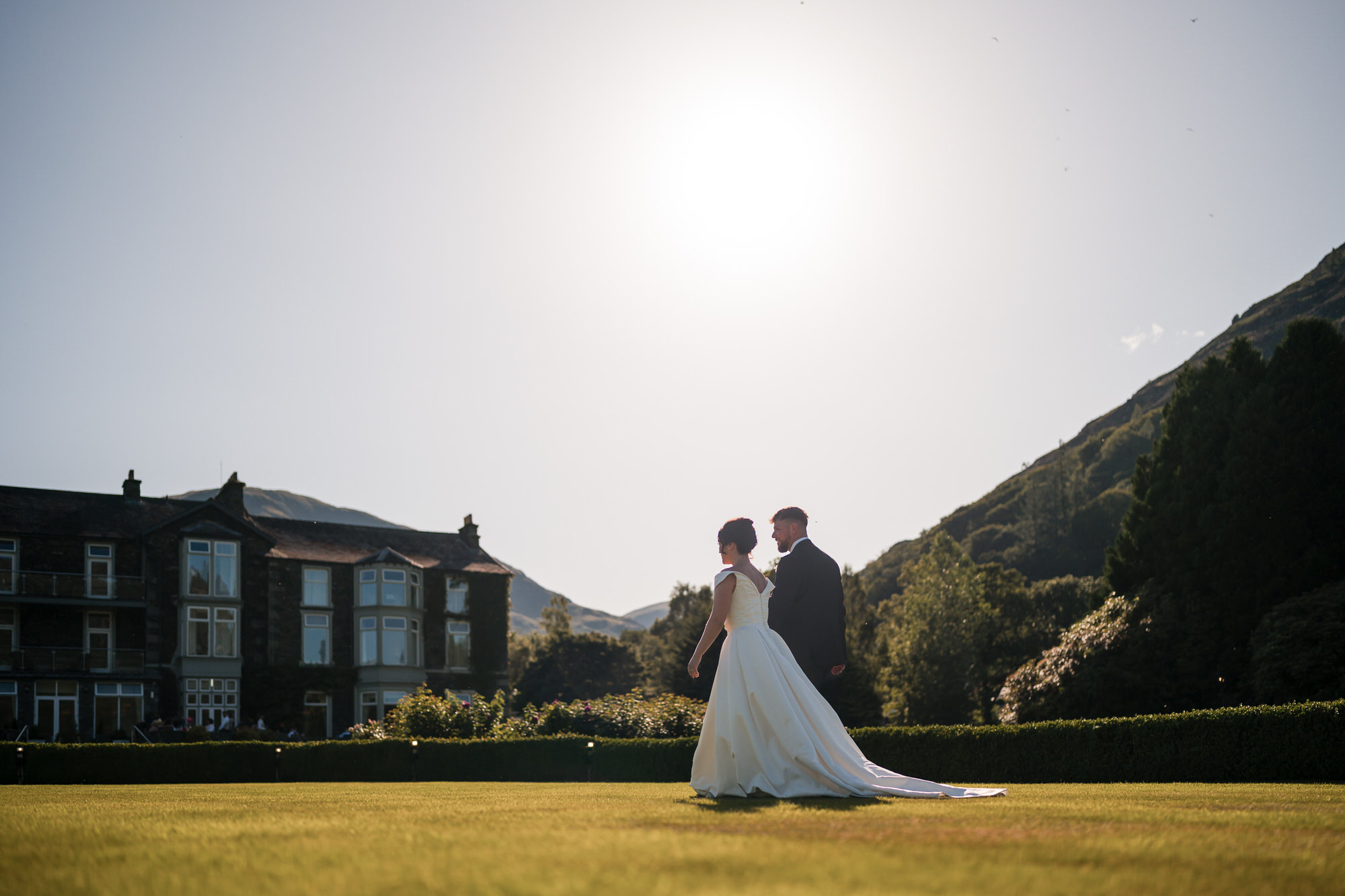 Dan and Amy walking across the lawn at Inn on the Lake in warm evening light