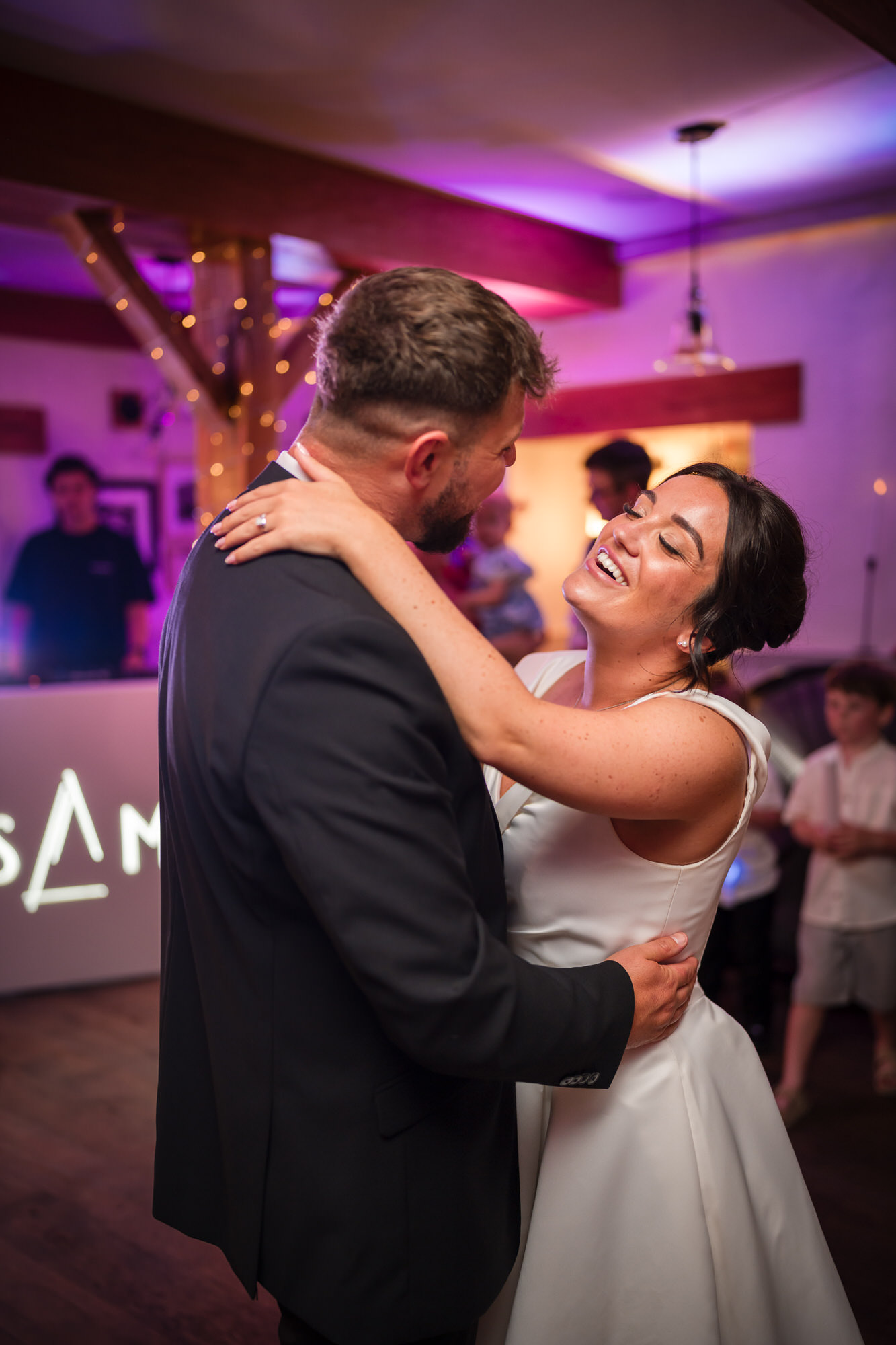 Amy laughing as she dances with Dan during their evening reception