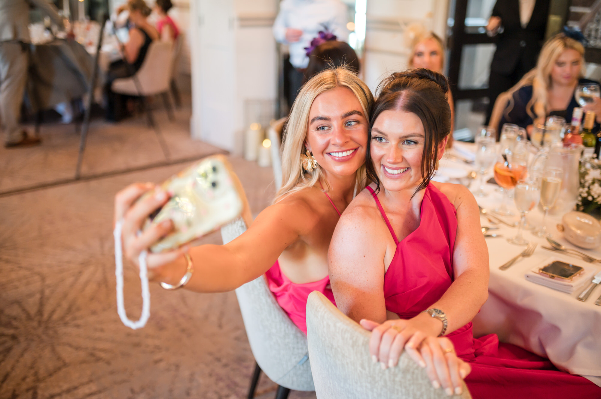 Two guests taking a cheerful selfie during the wedding breakfast