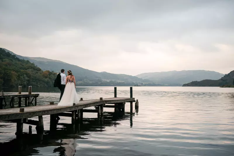 Wedding couple walking on the Ullswater jetty at Inn on the Lake
