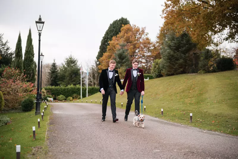 Gay wedding couple walking their dog at Broadoaks Country House