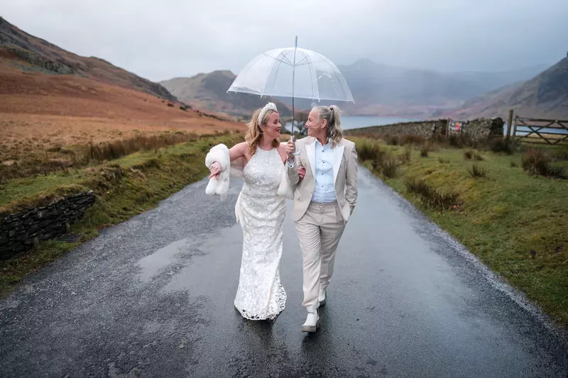 Lesbian wedding rain walk with Lake District mountains