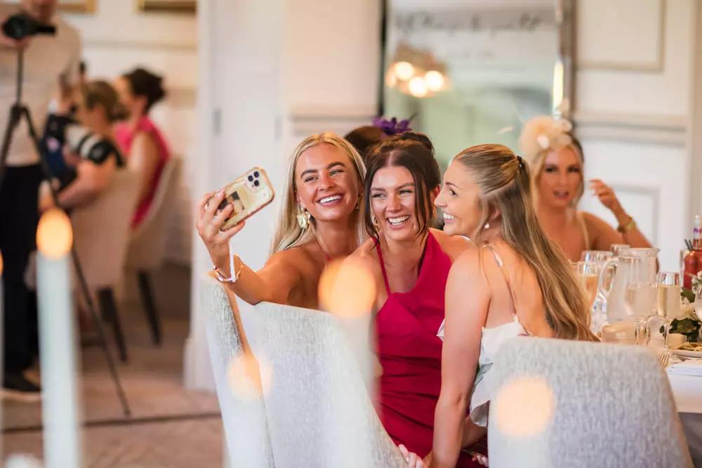 Couple entering wedding breakfast with guest reactions