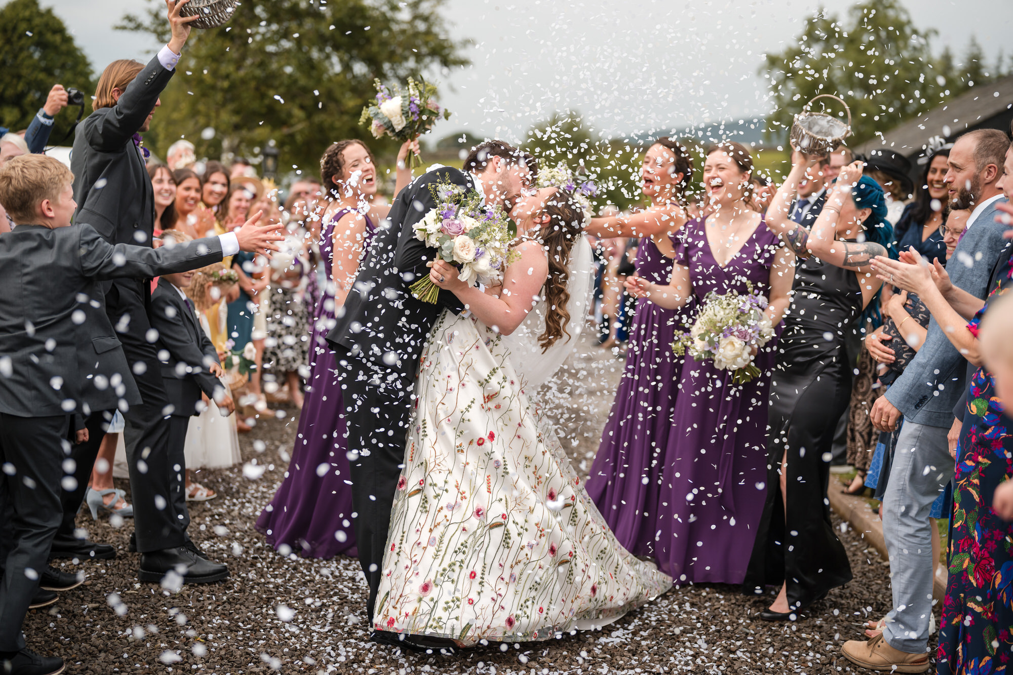 Wedding couple kissing during confetti at New House Farm