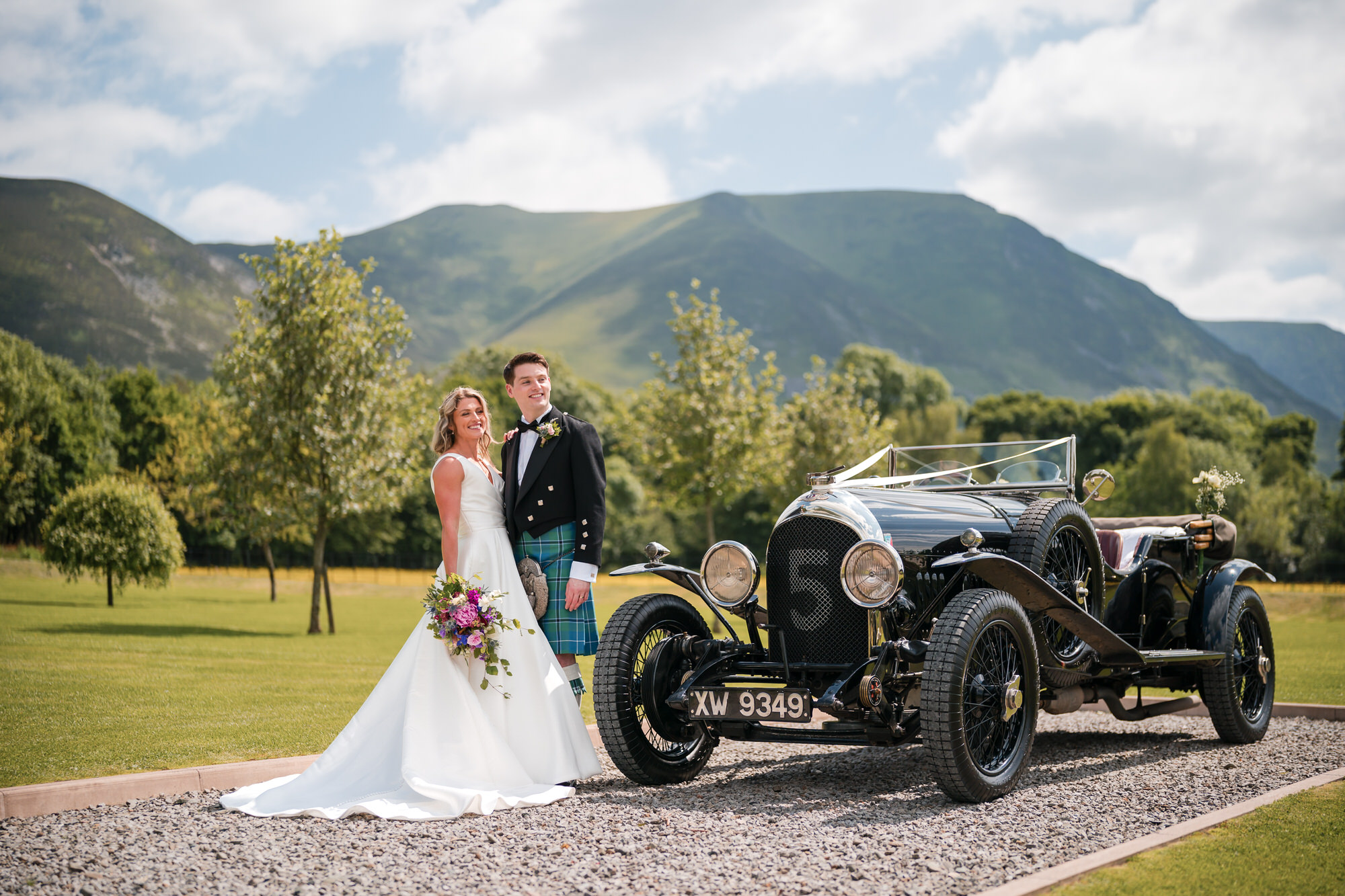 Wedding couple with a vintage car at New House Farm in the Lake District