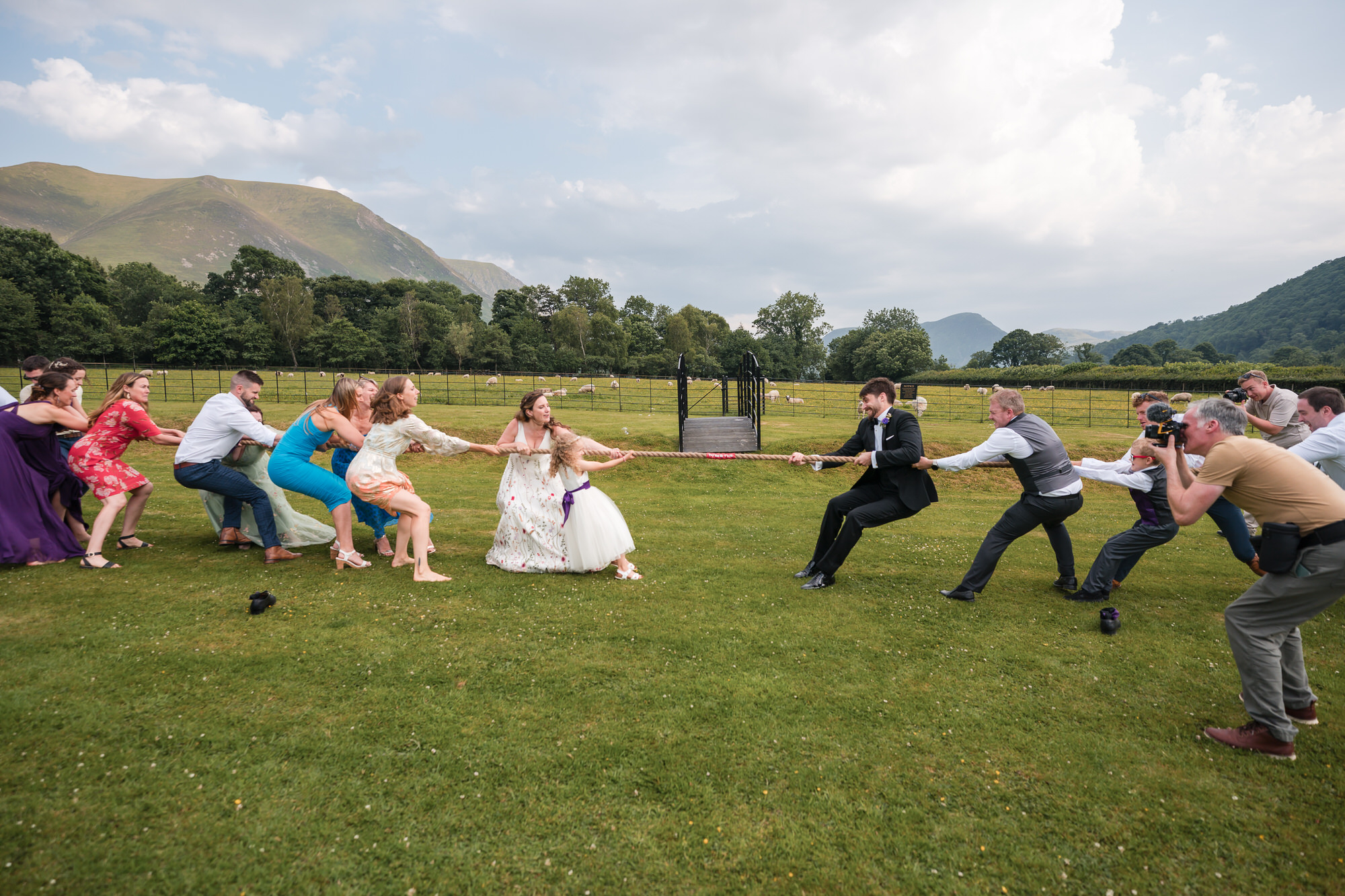 Wedding guests playing tug of war during lawn games at New House Farm