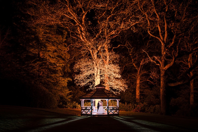 Night wedding portrait at Armathwaite Hall beside gazebo and illuminated trees