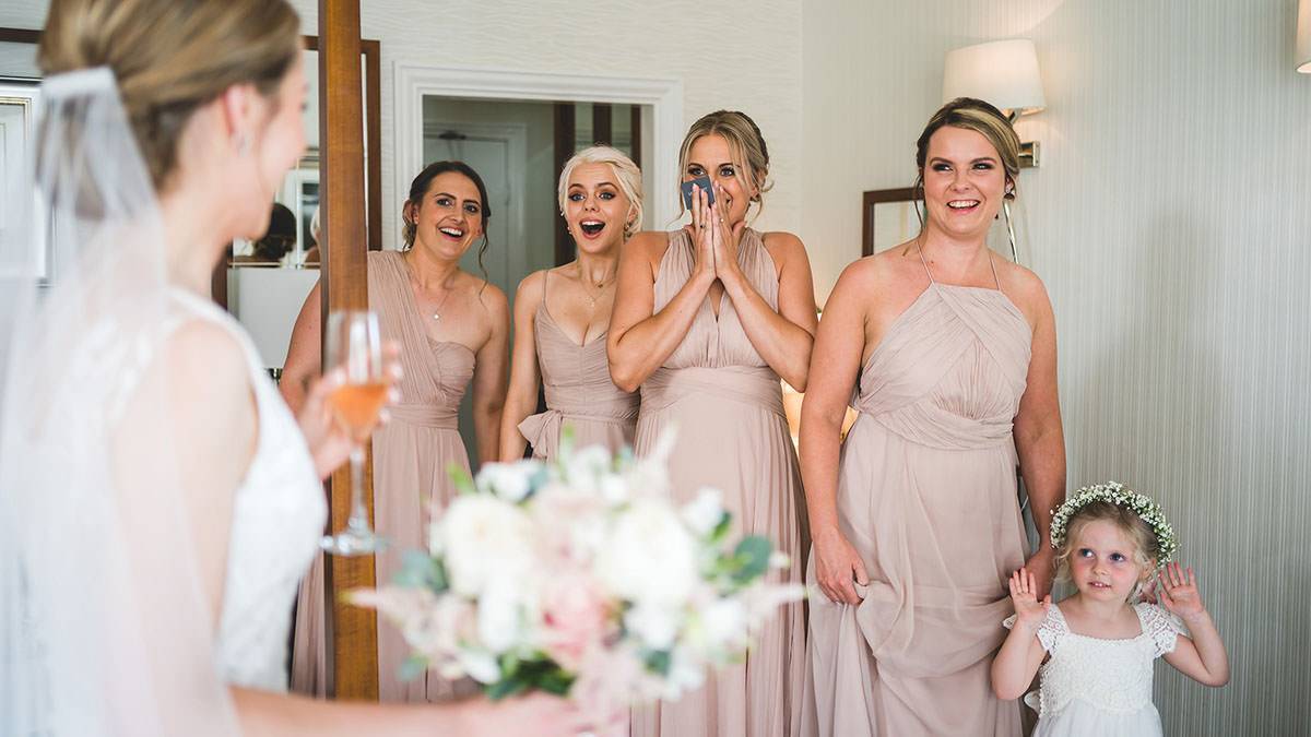excited bridesmaids seeing bride at inn on the lake
