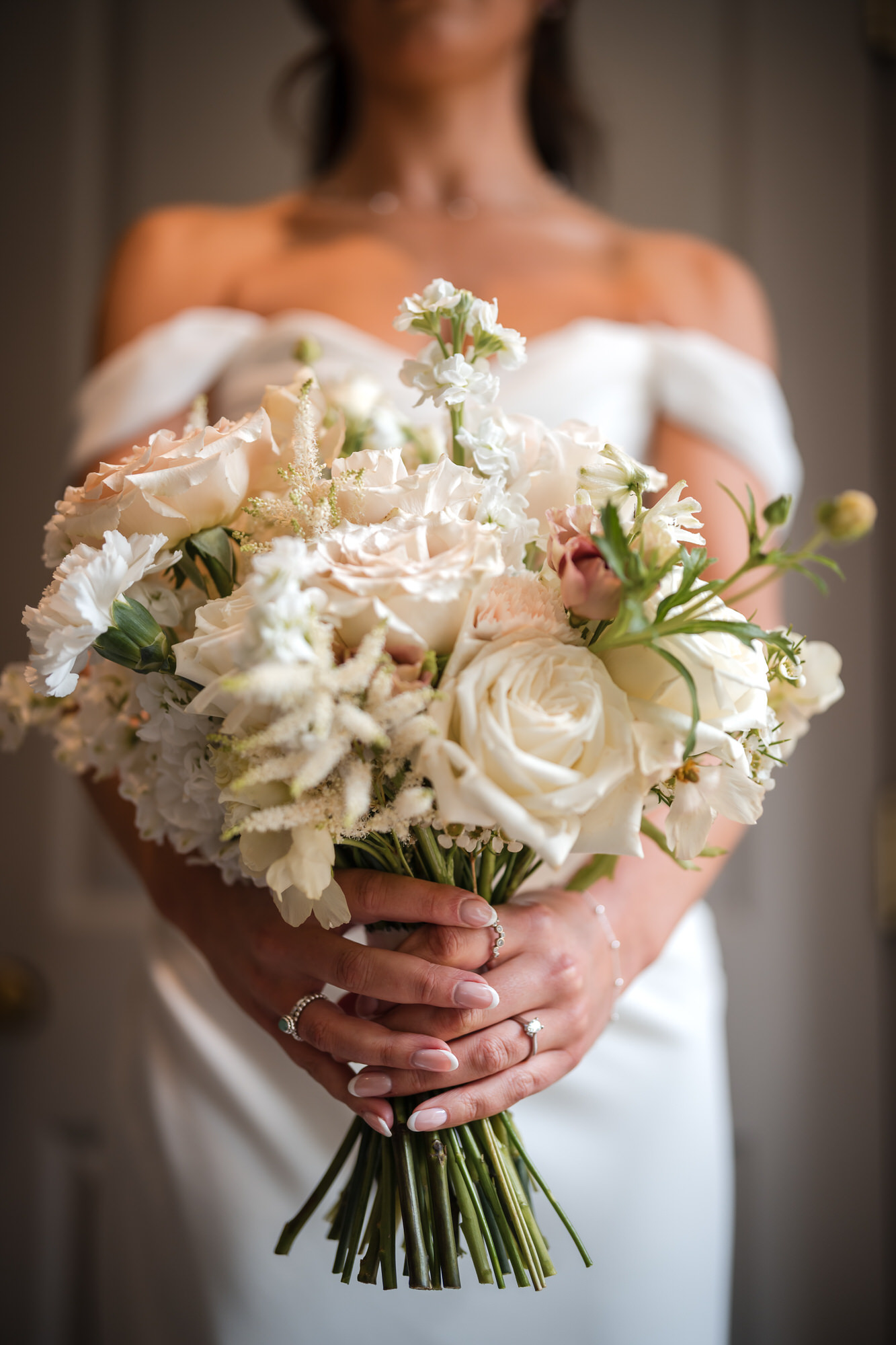 Ellie holding her bouquet of white and pale blush flowers