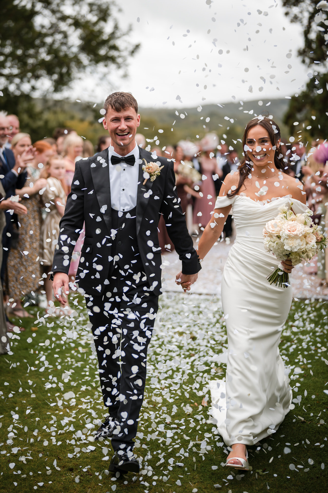 Dan and Ellie walking through a shower of confetti after their ceremony