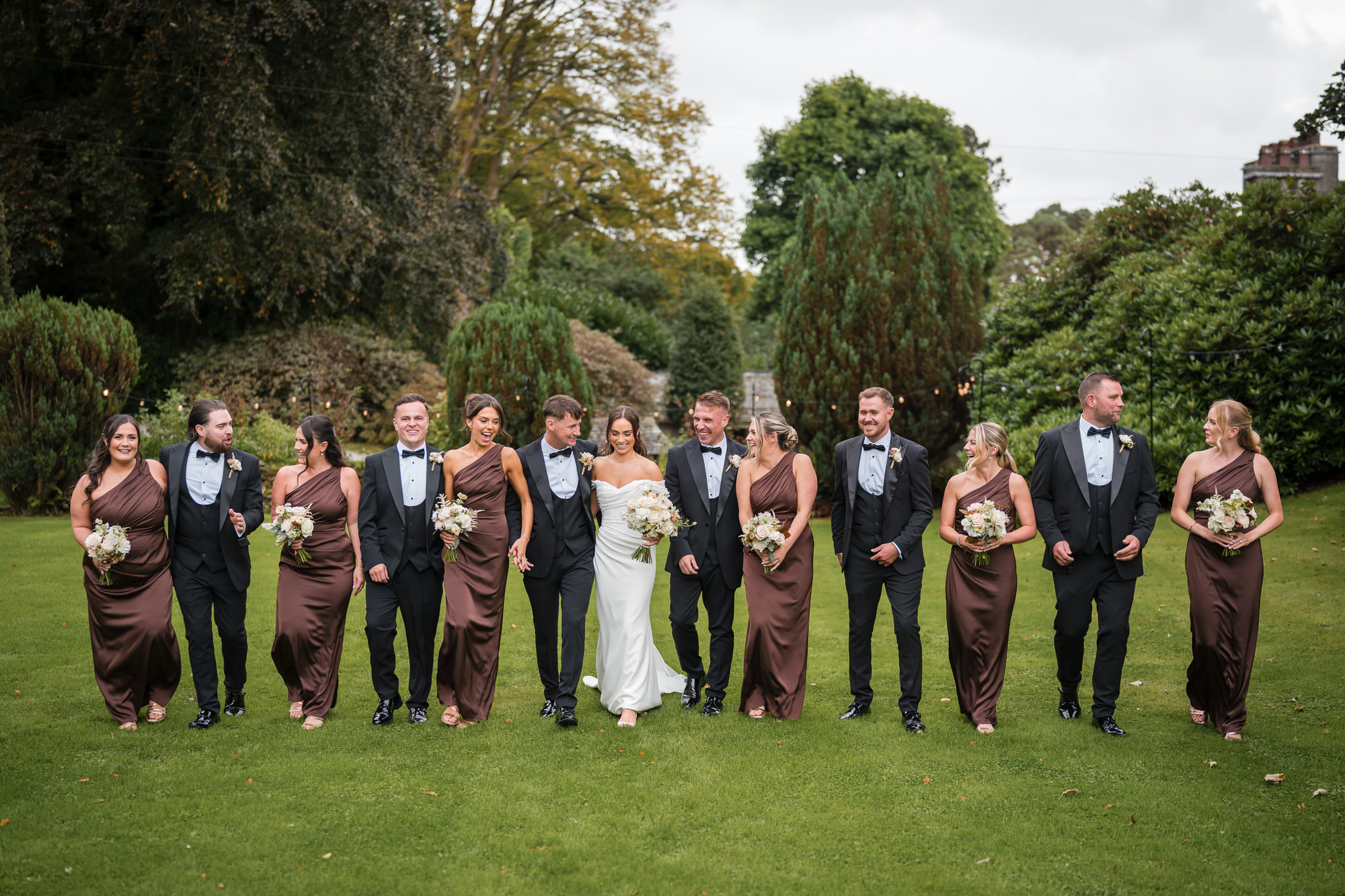 The wedding party walking together through the gardens