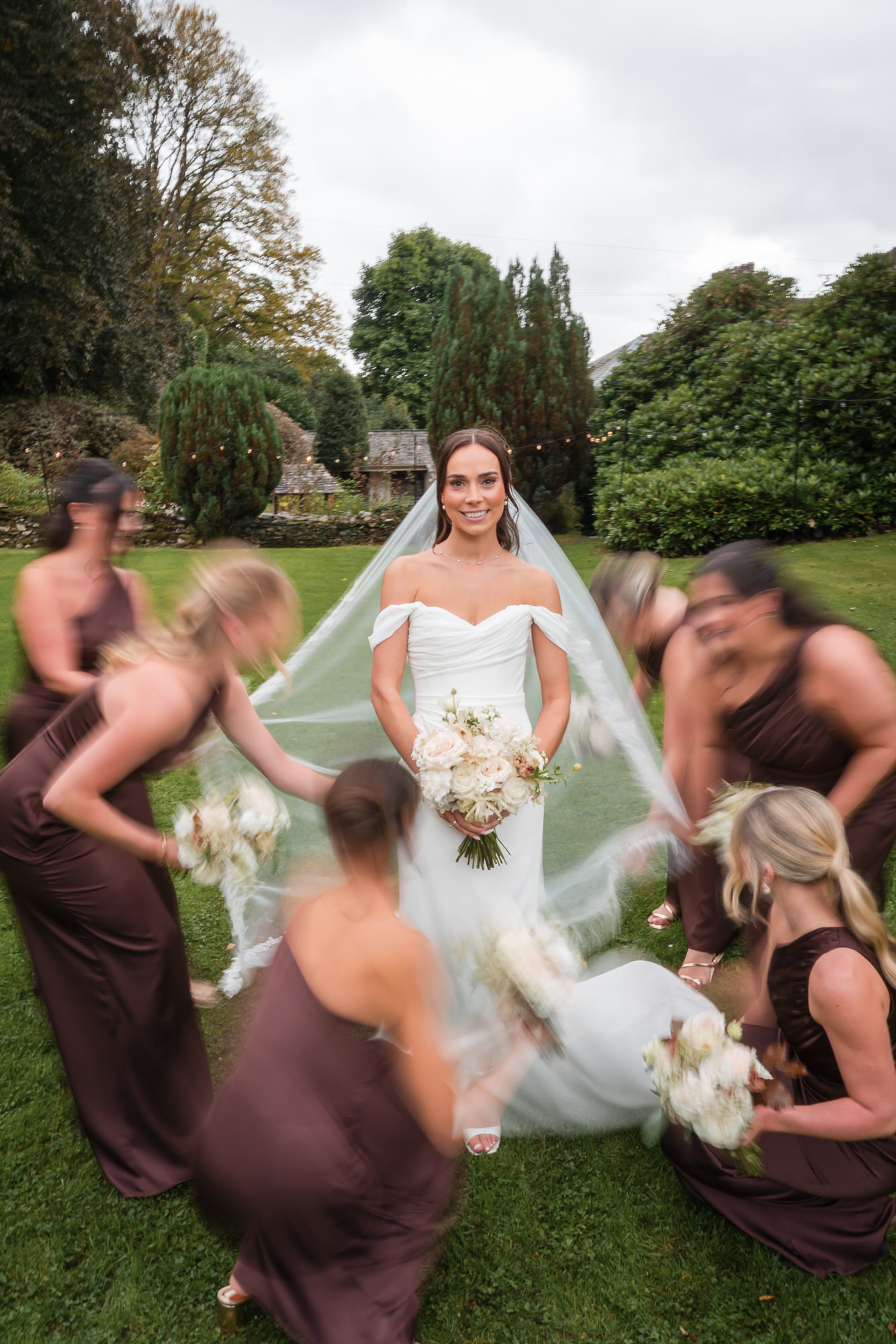 Ellie with her bridesmaids in a playful garden portrait