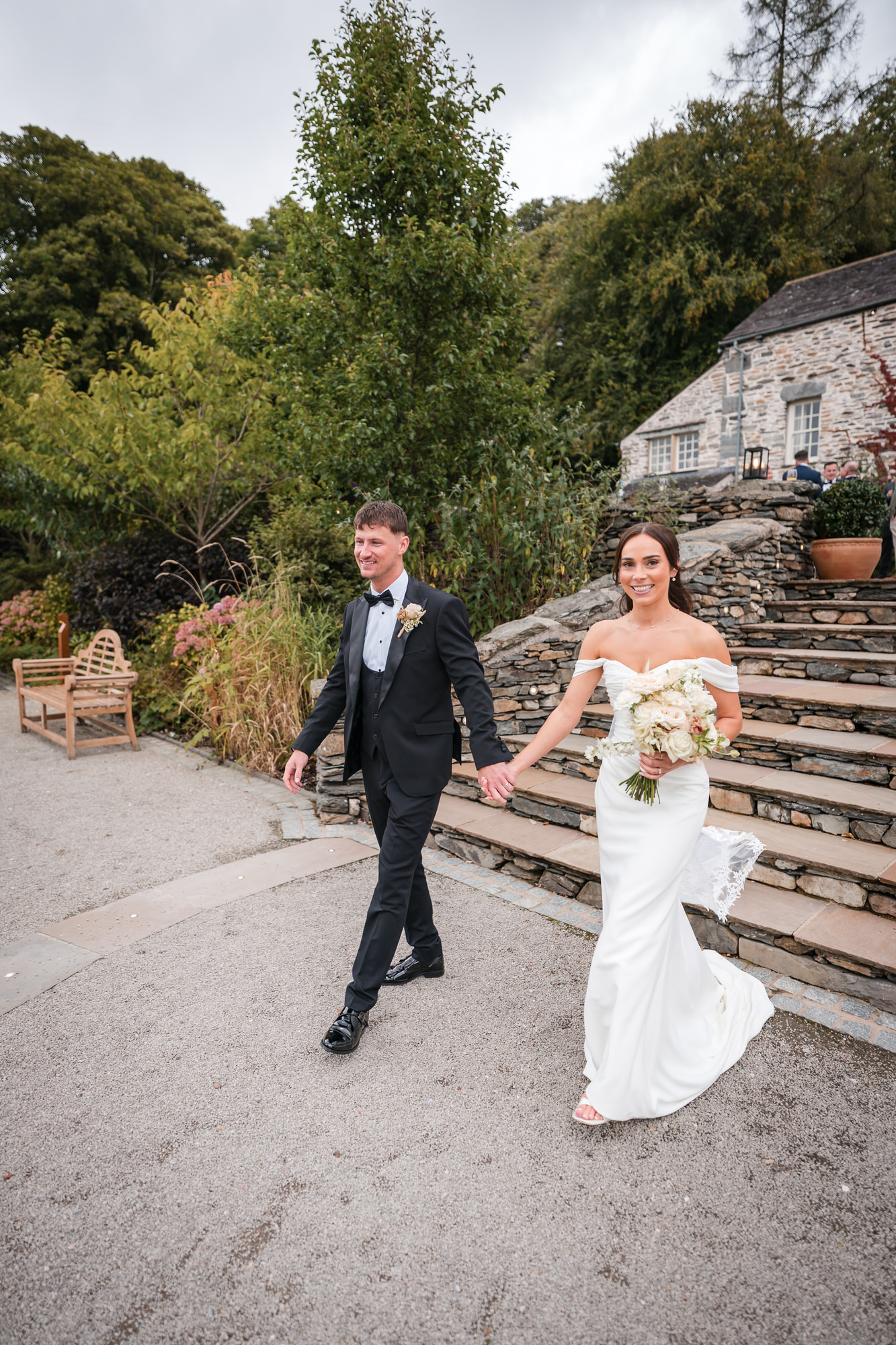 Dan and Ellie holding hands as they walk past the stone steps