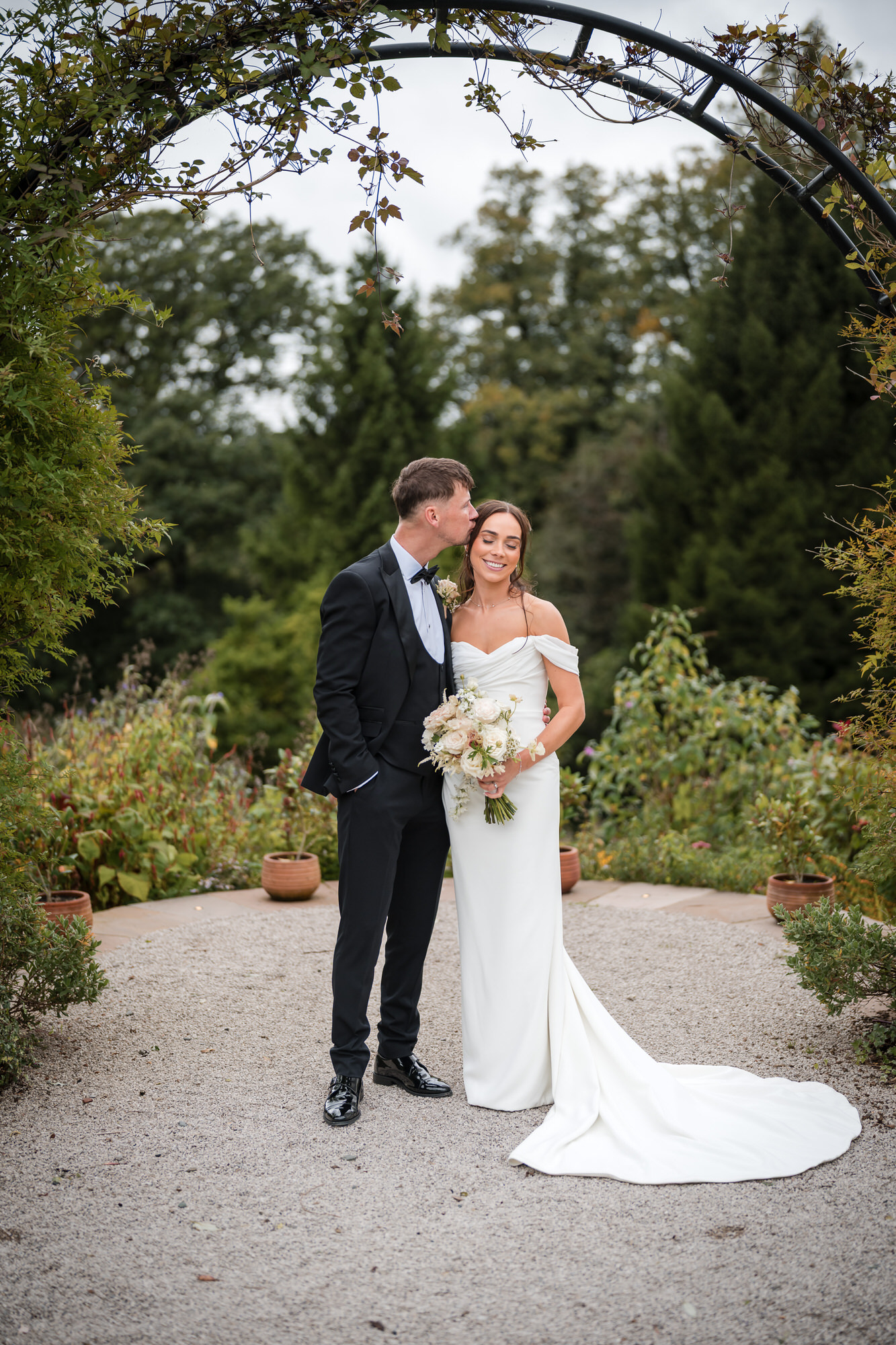 Dan and Ellie sharing a quiet moment beneath a garden arch