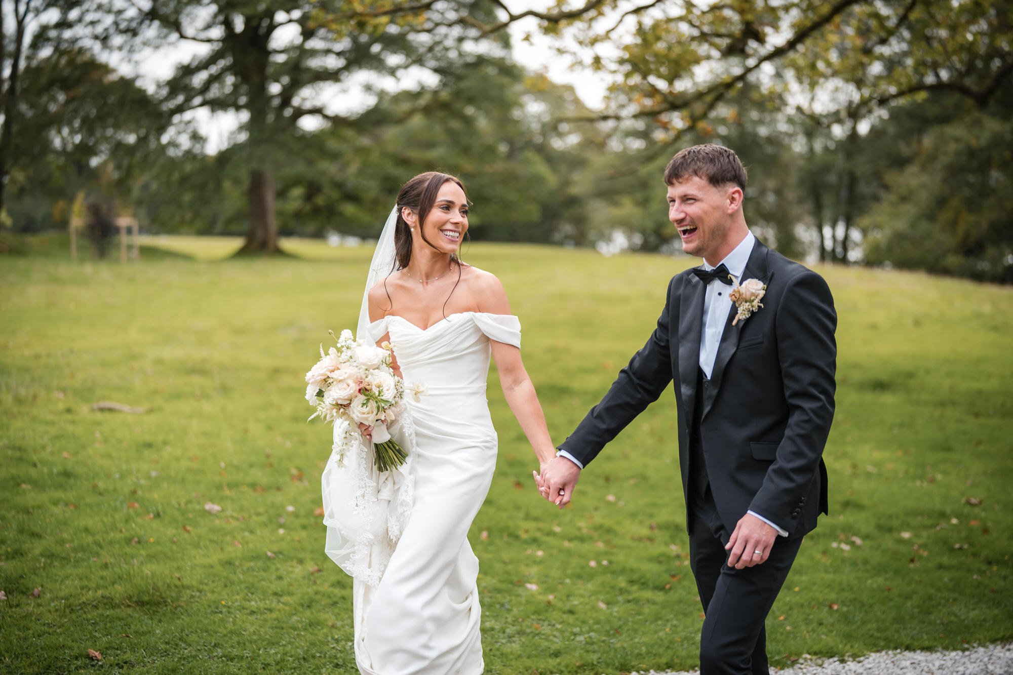 Dan and Ellie laughing as they walk back across the grounds