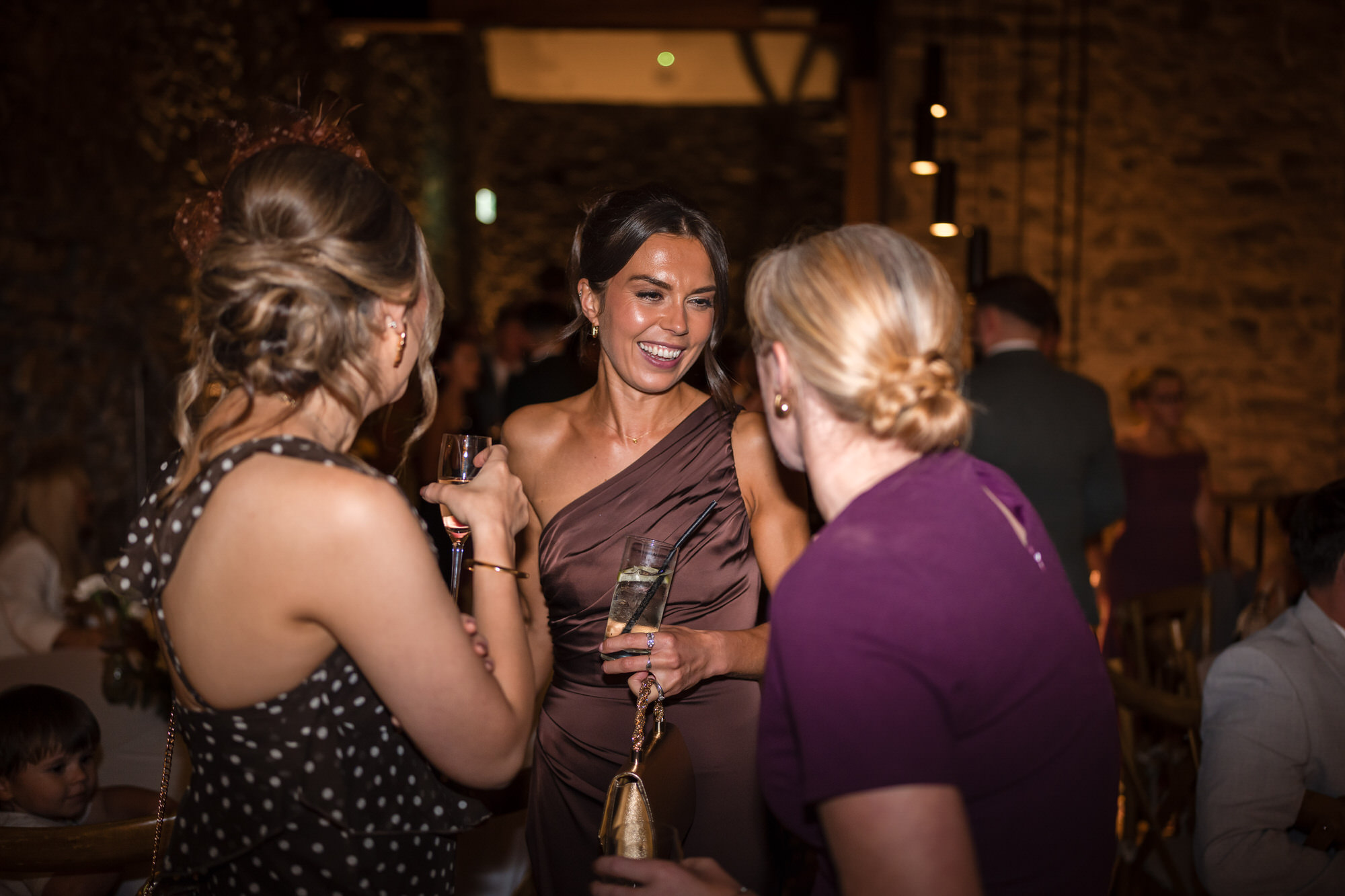 Ellie chatting with guests beneath the warm lights of the evening reception