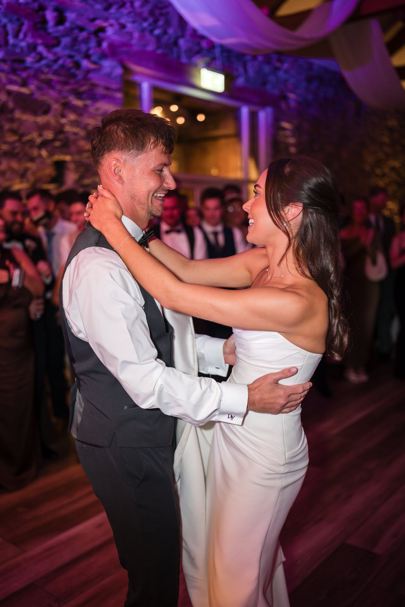Dan and Ellie dancing together surrounded by wedding guests