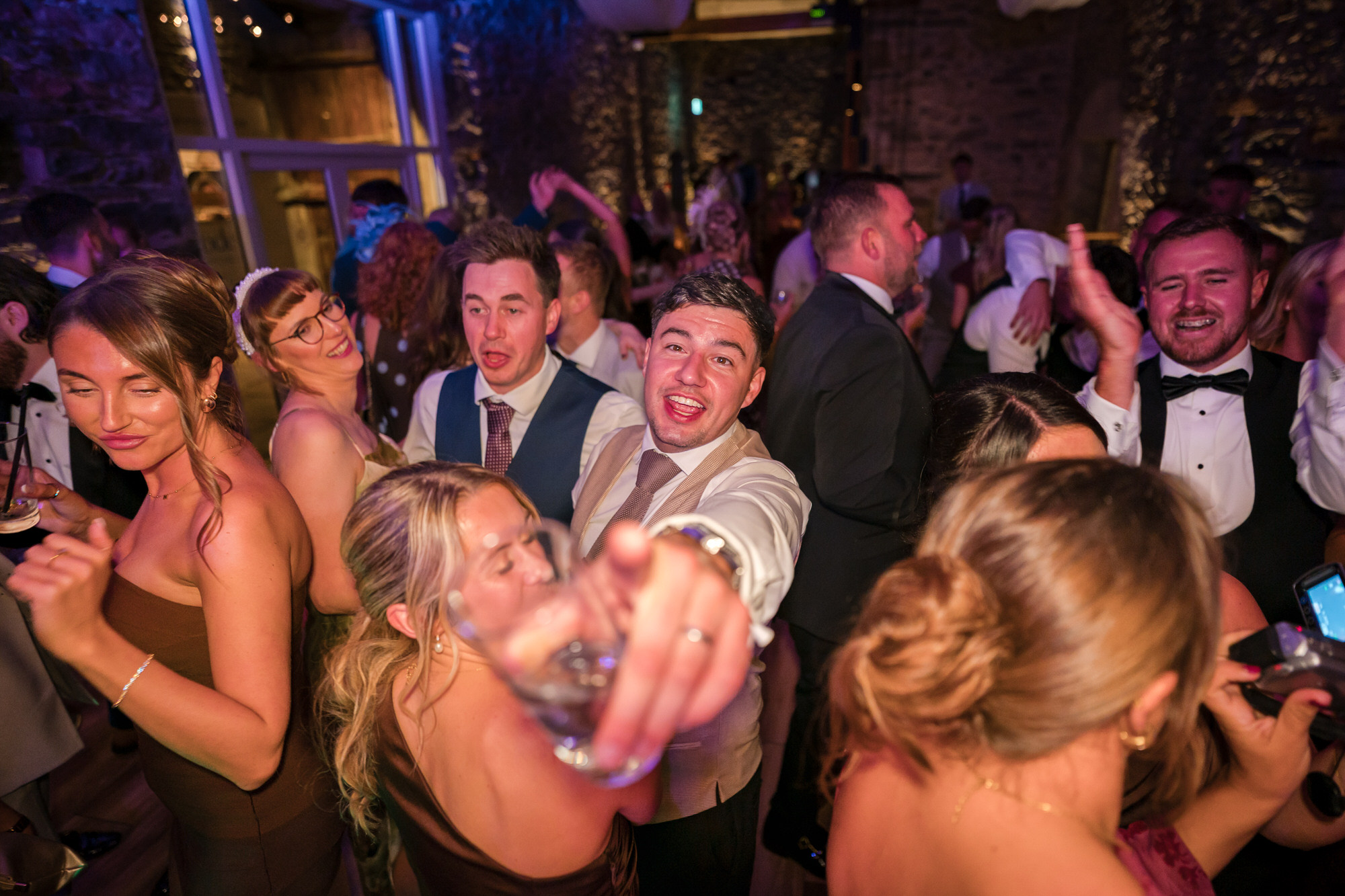 Friends dancing together at the lively evening reception