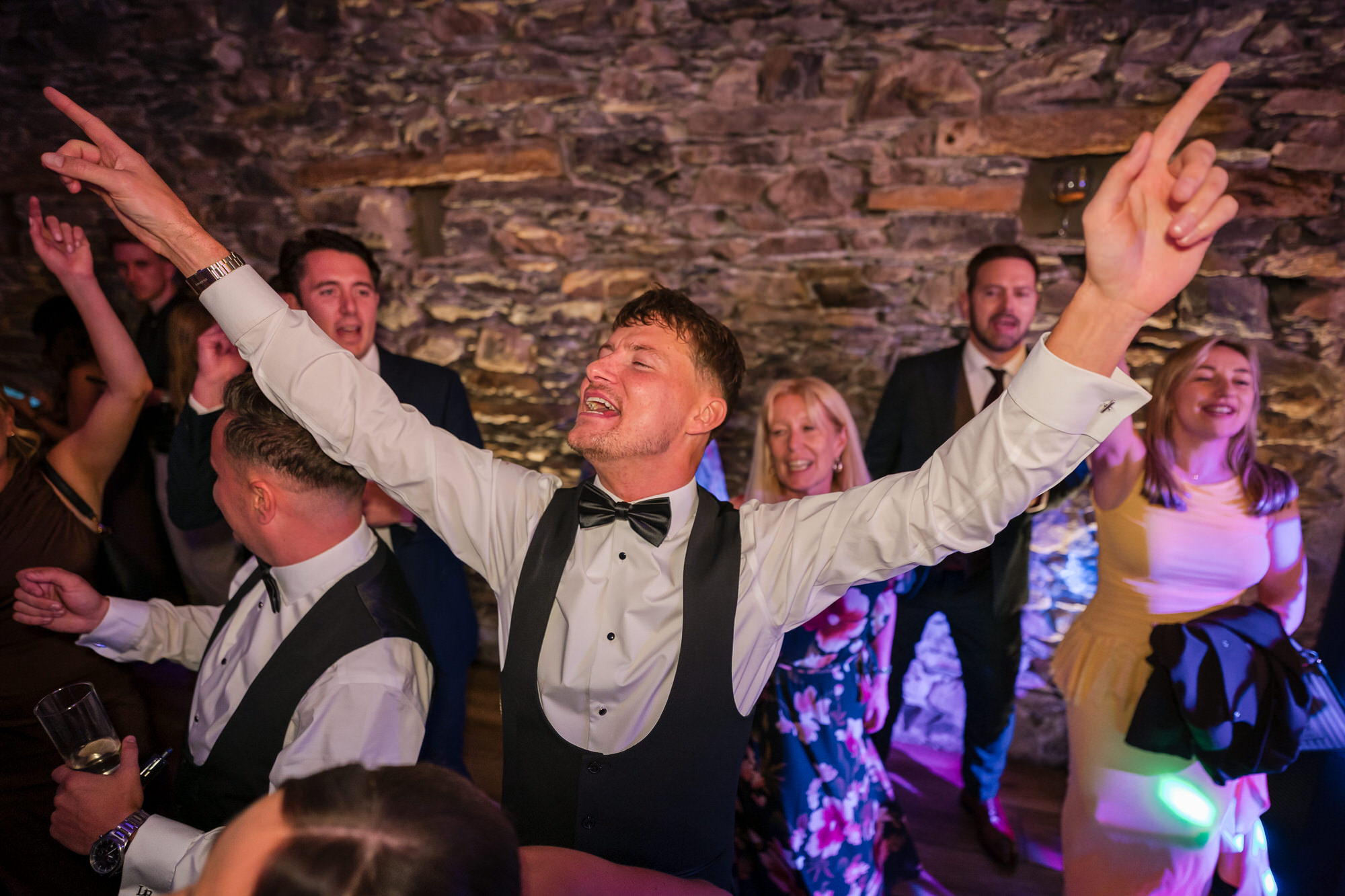 A guest raising both arms on the dance floor